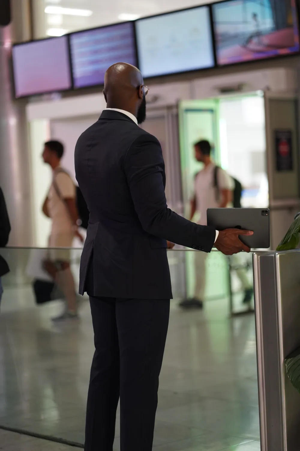 An Obrigado Transports driver waiting with a tablet at airport arrivals